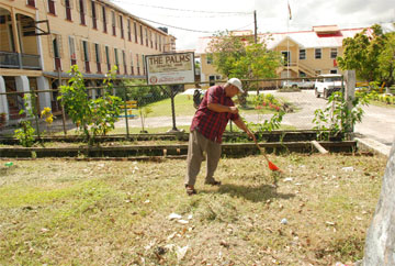 Man with a mission: Optician Don Gomes was captured by the roving lens of Stabroek News photographer Jules Gibson yesterday, cleaning the area outside The Palms Geriatric Home on Brickdam yesterday. Gomes has undertaken to clean the Brickdam Police Station lockups and that project, he said, will get underway as soon as maintenance work on the sewerage system at the station, which is critical, is completed.