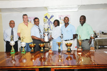 CEO of Namilco Bert Sukhai (third left) presents the 2008 Namilco Football Festival Trophy to Secretary of the Fruta Conquerors Lavern Fraser-Thomas (third right) while Namilco’s Operations  and Marketing Manager Ralph Hemsingh (second left) and Damon Pistano (second  right), GABA President Affeeze Khan (left) and Fruta Conquerors President Marlan Cole (right) look on. (Clairmonte Marcus photo)    