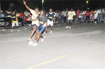 ‘he battle continues in the Guinness ‘Greatest of de Street’ football tournament Saturday evening on the National Cultural Centre’s Tarmac. (Clairmonte Marcus Photo)