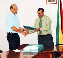 Minister of Agriculture, Robert Persaud (right) receives the report from Chairman of the Commission of Inquiry, Vic Oditt.
