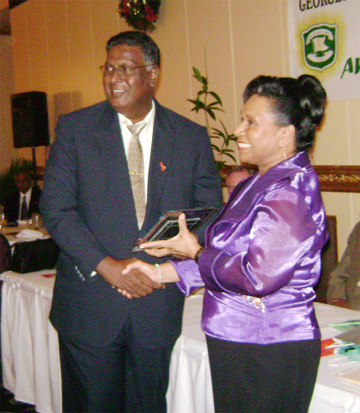 Community oriented: Denmor Garment Factory was awarded the Social Develop-ment Award by the Georgetown Chamber of Commerce and Industry at its Annual Dinner and Awards Presentation last night at the Pegasus Hotel. The company was recognized for its commitment to the promotion of diversity, corporate responsibility, the environment and community service. General Manager of Denmor, Dennis Morgan is photographed here accepting the award from Mrs. Yvonne Hinds.  