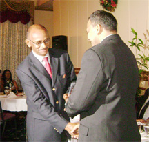 Minister of Culture, Youth and Sport Dr. Frank Anthony (right) presents the Customer Service Award to Lloyd Austin of Austin’s Book Store.   