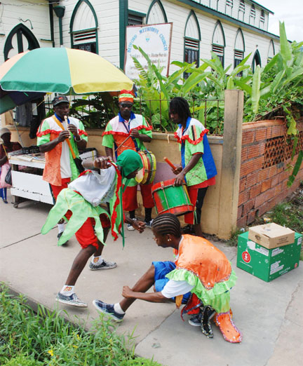 That time of the season: Masqueraders flouncing in the streets as part of the annual Christmas tradition. This group was photographed yesterday at the corner of Camp Street and North Road. (Jules Gibson photo)  
