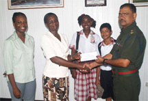 GDF Lieutenant Colonel Kemraj Persaud (right) hands over a cheque to David Rose Community High School Senior Mistress, Philomena Richmond-Jones as two students and another teacher look on.   