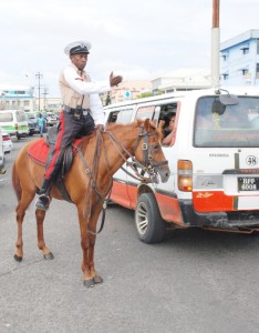 Horse power: A police officer directs traffic while perched on a horse on Water Street on Monday.  Christmas shopping has begun and traffic snarls in the city are becoming more frequent. (Photo by Jules Gibson)