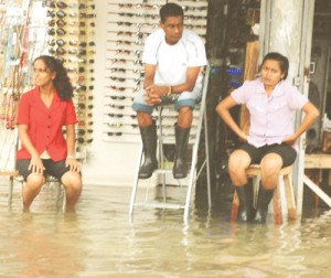 Going with the flow: Flooded out staff at a store at Regent and King streets yesterday.