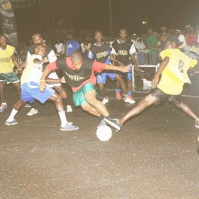 This East Front Road player (C) tries to take control of the ball as he is being tackled by Tiger Bay Hope Street players in the semi-final of the Guinness Greatest of De Street football competition. 