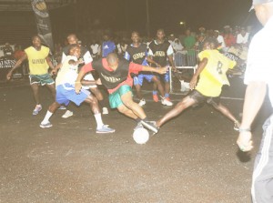 This East Front Road player (C) tries to take control of the ball as he is being tackled by Tiger Bay Hope Street players in the semi-final of the Guinness Greatest of De Street football competition. 