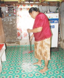 Banu Rashiv mopping out her ground floor kitchen at her Sherriga Housing Scheme, Enmore home yesterday. 