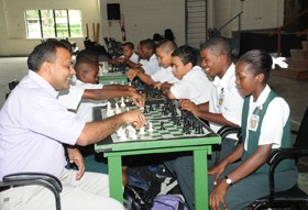 Minister of Sports, Dr Frank Anthony (left) makes the first move as the National School 2008 Chess championships get underway. (Clairemonte Marcus photo)