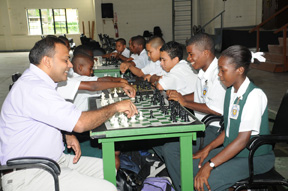 Minister of Sports, Dr Frank Anthony (left) makes the first move as the National School 2008 Chess championships get underway. (Clairemonte Marcus photo)