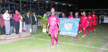 Defending Champions Alpha ‘The Hammer’ United playing under the theme ‘Unity with Strength and Wisdom’ make their way past acting President Samuel Hinds who stands second from left and Minister of Sport Dr. Frank Anthony (L)in the opening ceremony of the 19th  Annual Kashif and Shanghai tournament. (Lawrence Fanfair photo)