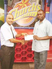In this Rawle Toney photo Director of Church’s Chicken Gregory De Gannes (left) hands over a cheque to Director of the Kashif and Shanghai organization Aubrey ‘Shanghai’ Major.