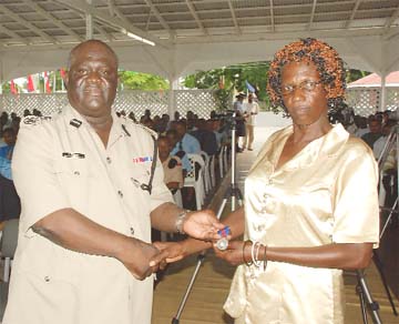 Doreen Glasgow, the mother of slain detective constable Oslyn Travis Glasgow, receiving the Commissioner’s Medal of Honour from Acting Police Commissioner, Henry Greene for his bravery. (Jules Gibson photo) 
