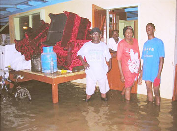 Joseph and Merlyn Arthur (left) standing in their flooded bottom-flat. They had to lift their furniture to safety. 