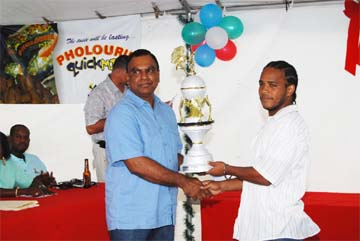 Namilco Managing Director Bert Sukhai, left, presents the 2008 Namilco Football Festival Trophy to captain of the winning team Alpha ‘The Hammer’ United Leon Grumble (right) at a ceremony hosted to mark the end of the competition. 