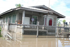 Swamped! This flat house at Bachelor’s Adventure, East Coast Demerara was completely surrounded by water yesterday, which undoubtedly would have gone inside as well. (Photo by Jules Gibson)