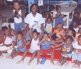 National long distance queen Alika Morgan strikes a pose with the children of the Red Cross Home, after distributing the gifts.  