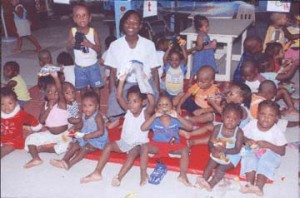 National long distance queen Alika Morgan strikes a pose with the children of the Red Cross Home, after distributing the gifts.  