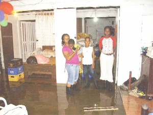 Isla Chester and family in ankle-deep water in their living room
