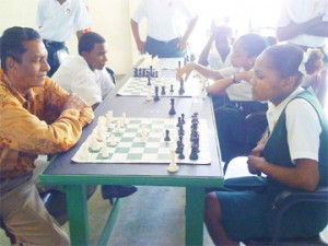 President of the Guyana Chess Federation Errol Tiwari takes on Ms Ashanti Richmond of McKenzie High in Linden in a friendly encounter during the National Schools Chess Championship.