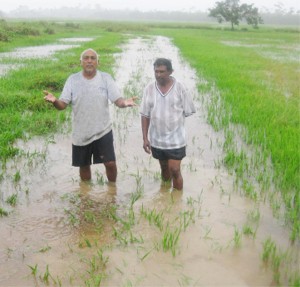 ‘What next?’ asks Imam Hussain as he stands on a section of the flooded dam with Mokshatam Persaud.