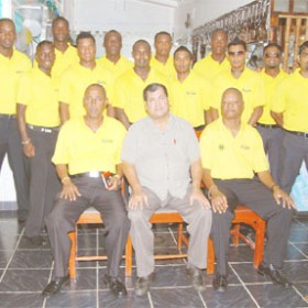 The Guyana team minus wicket-keeper Darwin Christian, prior to its departure for the  Cheddi Jagan International Airport (CJIA) yesterday. President of the Guyana Cricket Board (GCB) Chetram Singh, sitting, is flanked by Carl Moore, left and Albert Smith. (A Lawrence Fanfair photograph) 