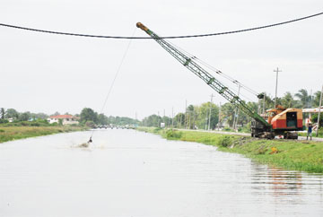 This dragline was cleaning a trench at Greenfield yesterday afternoon. Most of the floodwater has receded from this community.  