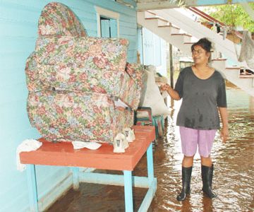 Leela Khandai, a Beehive resident, points to her chair which has been elevated for several weeks because of the floodwater in her house and yard. 