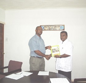 Director of the Environmental Protection Agency’s Natural Resources Management Division, Dr Indarjit Ramdass (right) hands over the National Biodiversity Action Plan 11 to Rickford Vieira, WWF-Guianas Regional Goldmining Pollution Abatement Coordinator at the WWF Office on Irving Street on Thursday. 