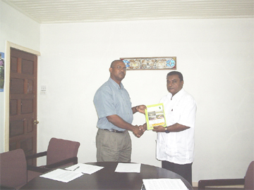 Director of the Environmental Protection Agency’s Natural Resources Management Division, Dr Indarjit Ramdass (right) hands over the National Biodiversity Action Plan 11 to Rickford Vieira, WWF-Guianas Regional Goldmining Pollution Abatement Coordinator at the WWF Office on Irving Street on Thursday. 