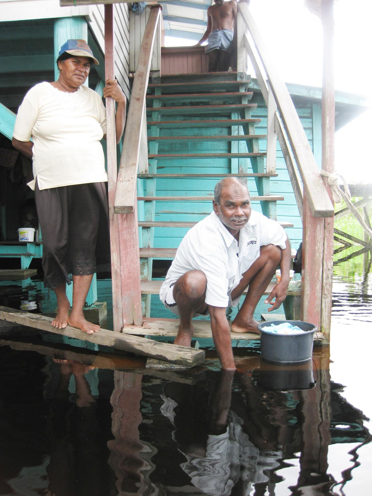 Hariram Ramkellawan shows that the 2006 flood was lower while his wife Lakhrajie looks on.