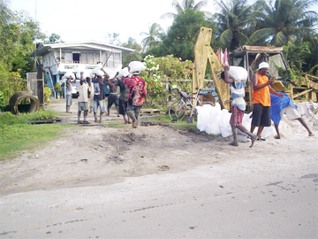 Workers fetching sandbags to place them at a low-lying portion of the Mahaica Creek bank at Supply, Mahaica yesterday. (See centre pages) 