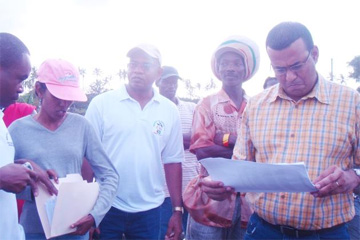 Agriculture Minister Robert Persaud checks the list of farmers in Victoria. (GINA photo) 