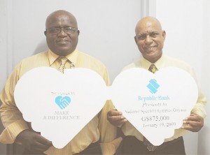 Special Olympics Presentation! President and National Director of the Special Olympics Guyana Organization Affeeze Khan (right) and Wilton Spencer  display the commitment  for sponsorship of G$875,000 they received from Republic Bank. (Clairmonte Marcus photo)  