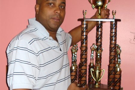 Former Linden basketballer Kenny Chapman shows off this giant trophy which will be up for grabs at the Victory Valley Royals basketball club’s annual schools championships. (Photo courtesy of Gary Tim)  