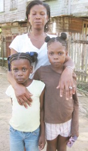 The distraught Erica Johnson with her two other daughters, Tovany (right) and Kiszy.  