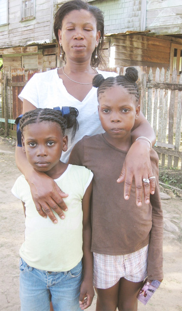 The distraught Erica Johnson with her two other daughters, Tovany (right) and Kiszy.  