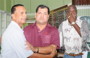 NO HARD FEELINGS! Challenger Bishwa Panday, left,  and Guyana Cricket Board (GCB) president Chetram Singh embrace following the result of yesterday’s annual general meeting as former national fast bowler Robert Adonis, right, wipes something (not a tear) from his eye. (Aubrey Crawford photo)   