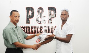 Trinidad bound: Travis Blyden receives his bowling boots from P & P Insurance head Bishwa Panday. 