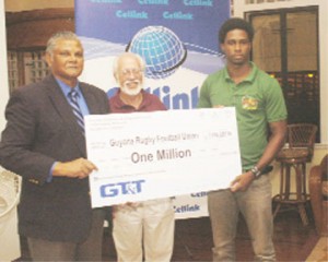 Chief Executive Officer of GT&T, Major General (retired) Joe Singh,  left, presents a sponsorship cheque for $1M to GRFU’s West Indies Sevens captain Claudius Butts (right). Kit Nascimento, president of the West Indies Rugby Union, stands at centre. (Aubrey Crawford photo)    