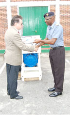 Commodore Gary Best (right) receives the generator from Brazilian Ambassador Arthur Meyers.