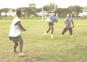 Claudius Butts, right, prepares to receive a pass from Albert La Rose while fitness coach Cornel Millington watches closely. (Aubrey Crawford photo)  