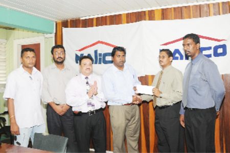 Assistant Secretary of the DCB Samaroo Jailal collects the cheque for $400,000 from Nalico/Nafico manager Shivraj Singh. Others in picture are (from left) Anand Sanasie, Pretipaul Singh, Bissoondial Singh and far right Nalico representative Yogendra Arjune. 