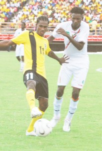 Gregory Richardson (left) in action for Guyana against Suriname at the Providence stadium during the second round of the FIFA World Cup qualifiers. (Lawrence Fanfair Photo)     
