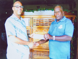 Project Manager of H. Nauth and Sons Construction Company, Julian Archer, left, hands over part of the race sponsorship to coach of the club Randolph Roberts.      