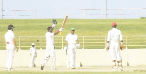 Watched by from left Justin Guillen, Devendra Bishoo and wicketkeeper Gibran Mohammed, Guyana’s Narsingh Deonarine (2nd left) soaks up the applause from his teammates after posting his fifth first class ton yesterday. (An Aubrey Crawford photograph)  