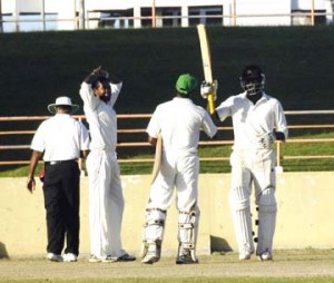 Watched by Trinidad and Tobago’s (T&T) spinner Imran Khan, Guyana’ s middle order batsman Narsingh Deonarine congratulates team mate Royston Crandon (bat in the air) after the latter posted his fourth first-class, half-century in Guyana’s second innings  against T&T at the Guyana National Stadium, Providence yesterday. (An Aubrey Crawford photograph)