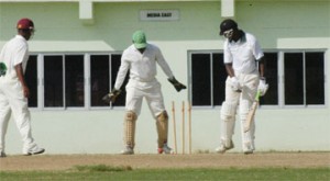 Windward Islands batsman  Shane Shillingford looks back to see his stumps disturbed by Devendra Bishoo as wicketkeeper Darwin Christian and short leg fielder Leon Johnson look on. (Aubrey Crawford photograph)        