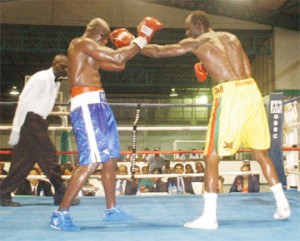 IN YOUR FACE! Howard `Battersea Bomber’ Eastman gets a jab through the  defence of  Leon “The Lion” Gilkes during their 10-round catch weight fight at the Cliff Anderson Sports Hall Saturday night. (Aubrey Crawford photo) 